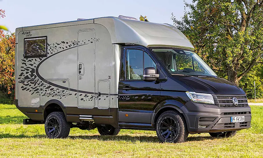 Der Woelcke Autark Crafter C4 (2025) auf einer Wiese stehend von schräg vorne rechts.