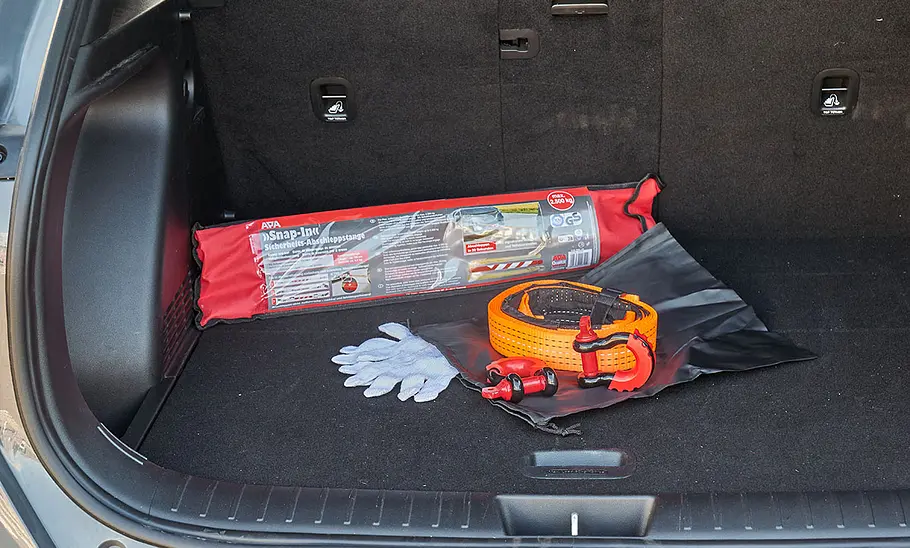 Abschleppstange und Abschleppseil im Test Abschleppstange und Abschleppseil im Kofferraum eines Autos, fotografiert von hinten.