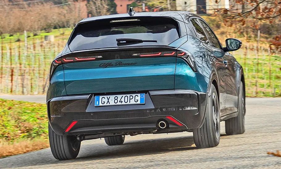Alfa Romeo Junior Ibrida (2024) Der Alfa Romeo Junior Ibrida (2024) auf einer Straße fahrend, Ansicht von hinten rechts.