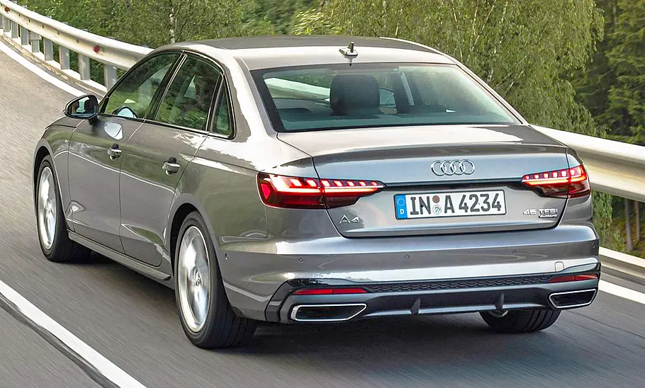 Der Audi A4 (2019) fährt eine Landstraße entlang, von hinten links fotografiert.