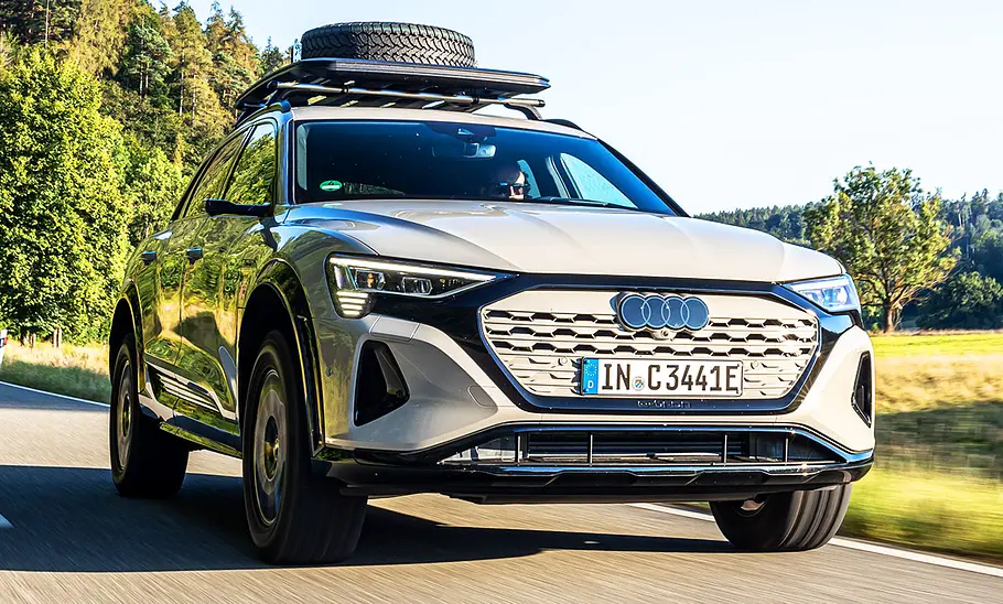 Der Audi Q8 e-tron Dakar Edition auf der Landstraße, von schräg vorne fotografiert.