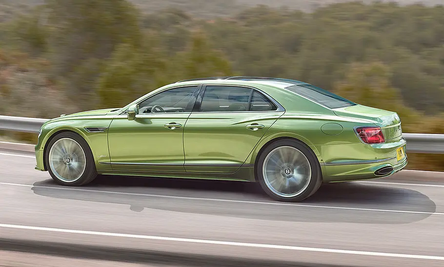 Das Bentley Flying Spur Facelift (2024) fährt durch eine leichte Rechtskurve, von links fotografiert.