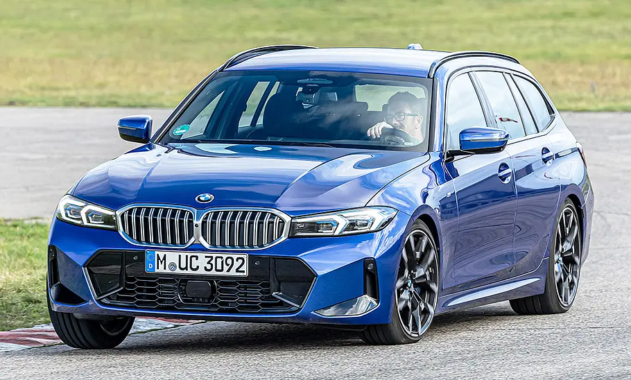 BMW 3er Touring Der BMW 3er Touring fährt durch eine Rechtskurve. Von vorne fotografiert.