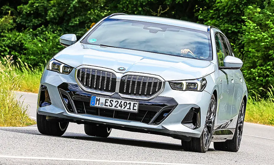 Blick von schräg vorne auf den fahrenden Kombi BMW 530e Touring.