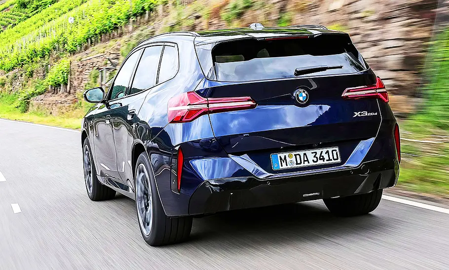 BMW X3 Blick von schräg hinten auf den fahrenden BMW X3.