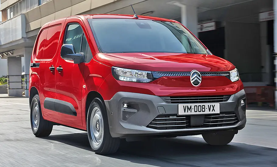 Das Citroën ë-Berlingo Facelift (2024) fährt durch eine Stadt, von vorne rechts fotografiert.
