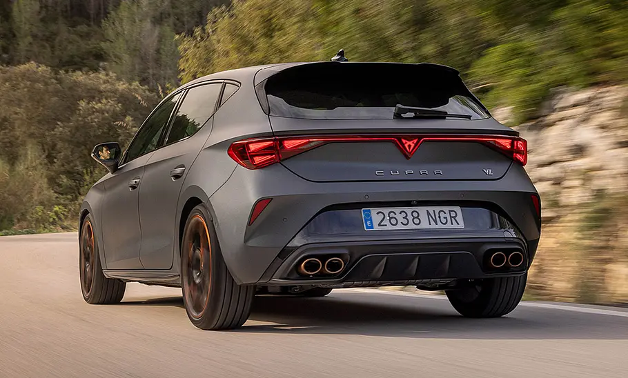 Cupra Leon VZ Der Cupra Leon VZ fährt auf einer Landstraße, von hinten links fotografiert.