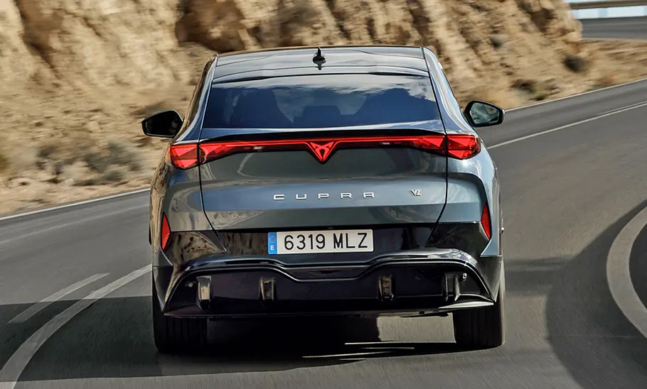 Der Cupra Tavascan (2024) fahrend von hinten fotografiert.