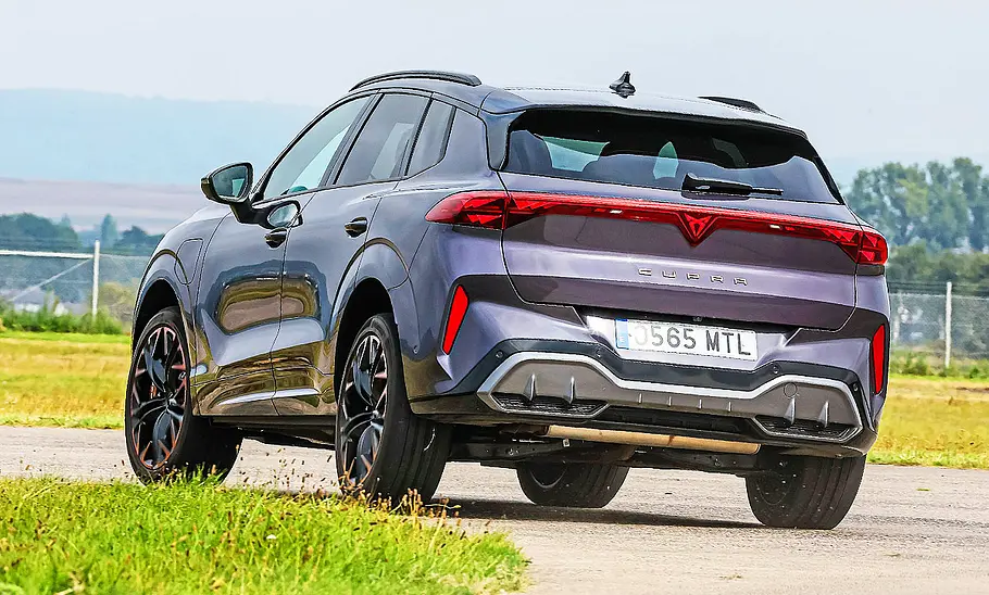 Cupra Terramar Blick von schräg hinten auf den fahrenden Cupra Terramar, der im sportlichen Fahrstil eine scharfe Kurve passiert.