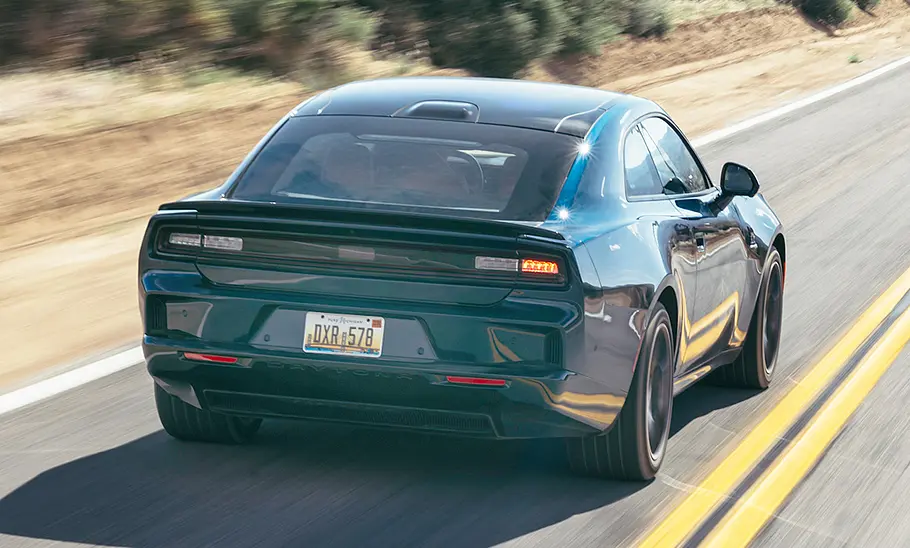 Dodge Charger Daytona (2025) Der Dodge Charger Daytona (2025) fährt eine US-amerikanische Landstraße entlang, von hinten rechts fotografiert.