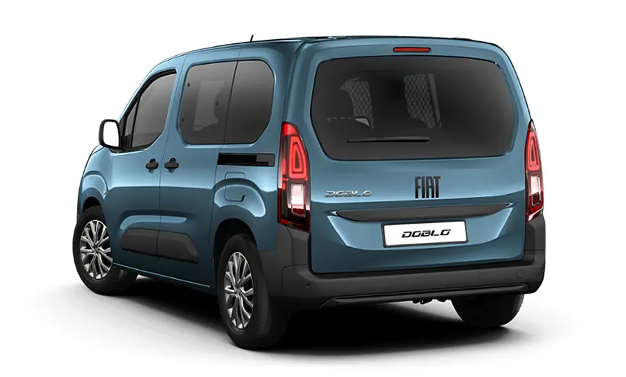 Fiat (E-)Doblò Facelift (2024) Die Kombivariante des Fiat (E-)Doblò Facelift (2024) steht vor weißem Hintergrund, von hinten links fotografiert.