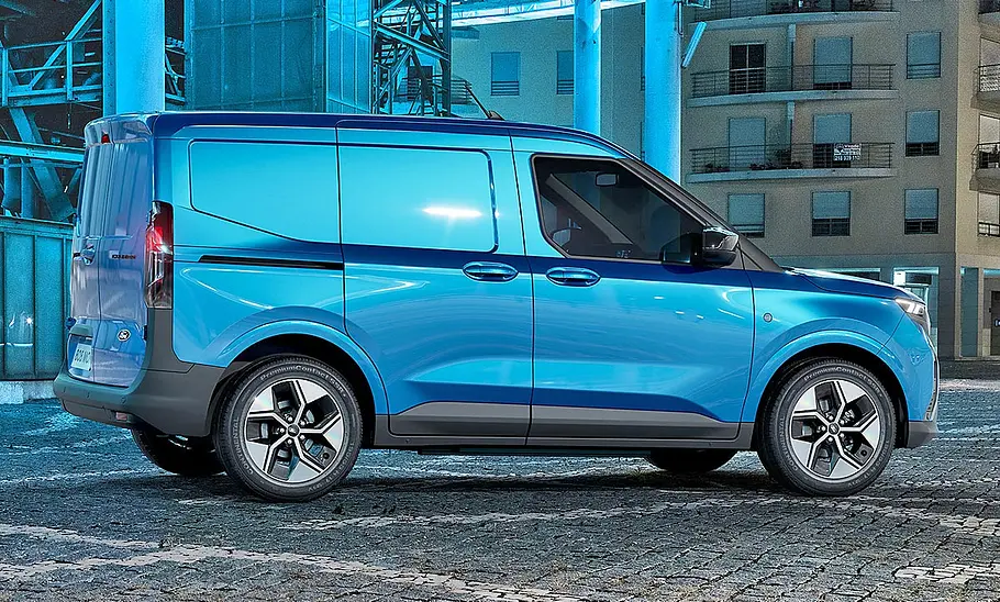 Der Ford E-Tourneo Courier (2025) fährt auf einer Straße, von rechts fotografiert.