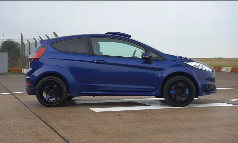 Ford Fiesta RS vor einem Flugfeld, fotografiert von der Seite: