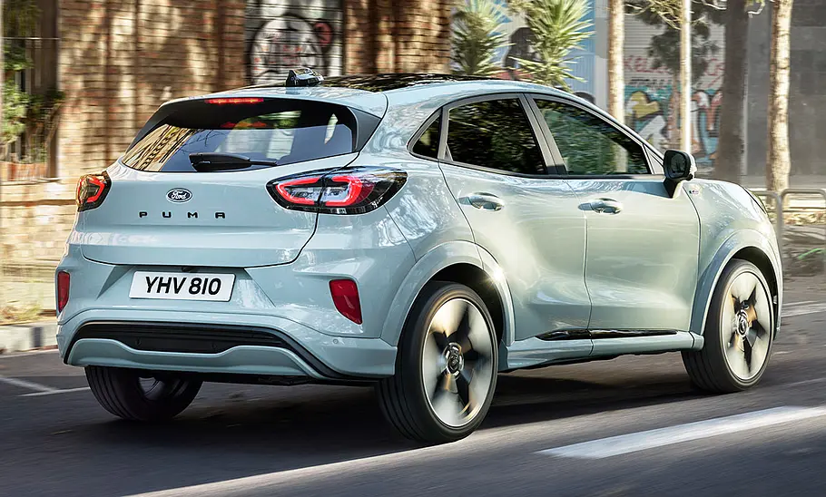 Das Ford Puma Facelift (2024) fahrend von schräg hinten.