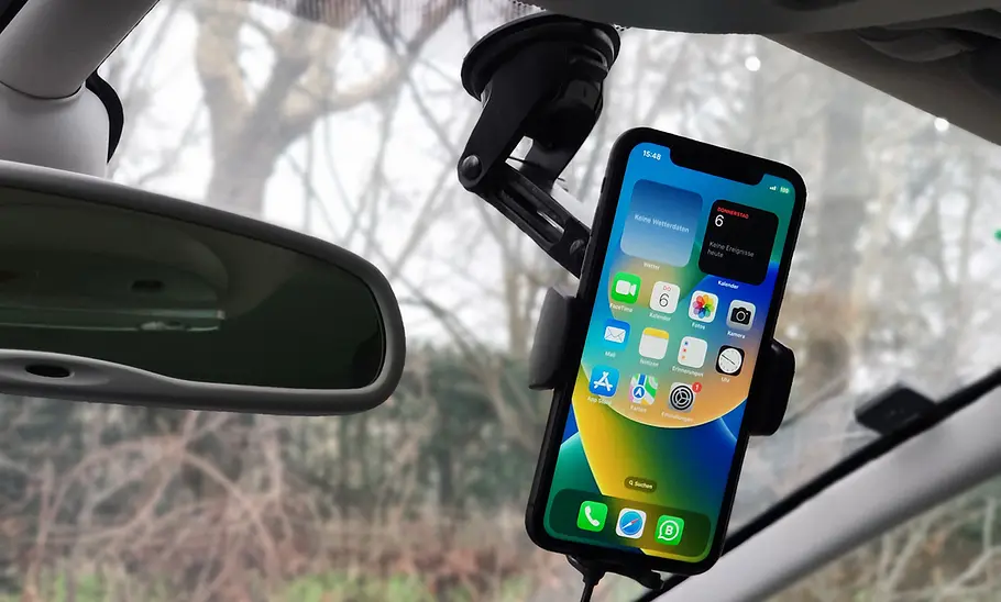 Handyhalterung fürs Auto mit Ladefunktion im Test Der Hama Wireless Car Charger an der Windschutzscheibe mit Handy im Hochformat.
