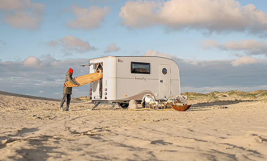 Die Außenaufnahme zeigt den Hobby Beachy 420+ (2025) statisch von schräg hinten rechts an einem Strand stehend.