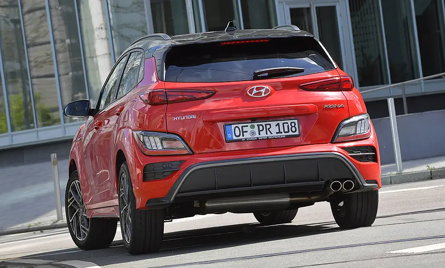 Hyundai Kona (2021) Der Hyundai Kona (2021) fährt in urbaner Umgebung, von hinten fotografiert.