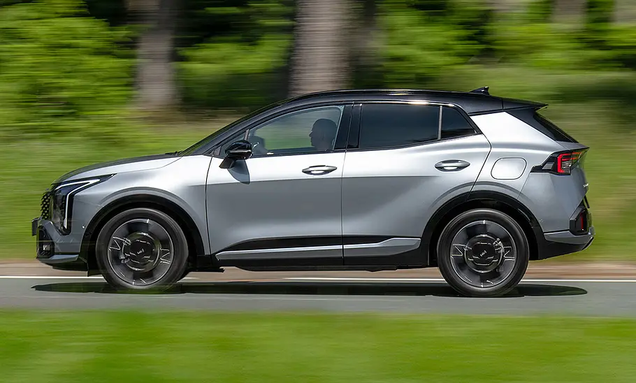 Kia Sportage (2025) Der Kia Sportage (2025) fährt auf einer Landstraße, von links fotografiert.