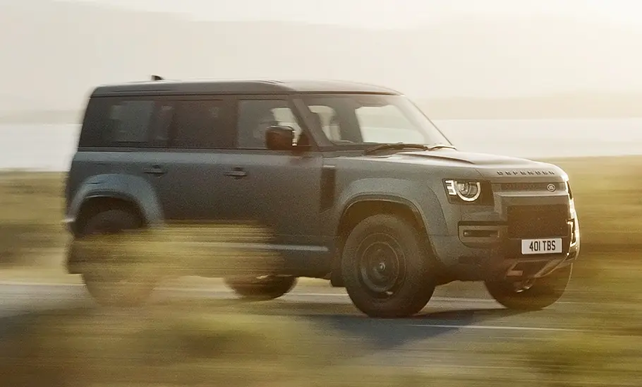 Land Rover Defender Octa (2024) fährt auf einer Landstraße, Ansicht von rechts.