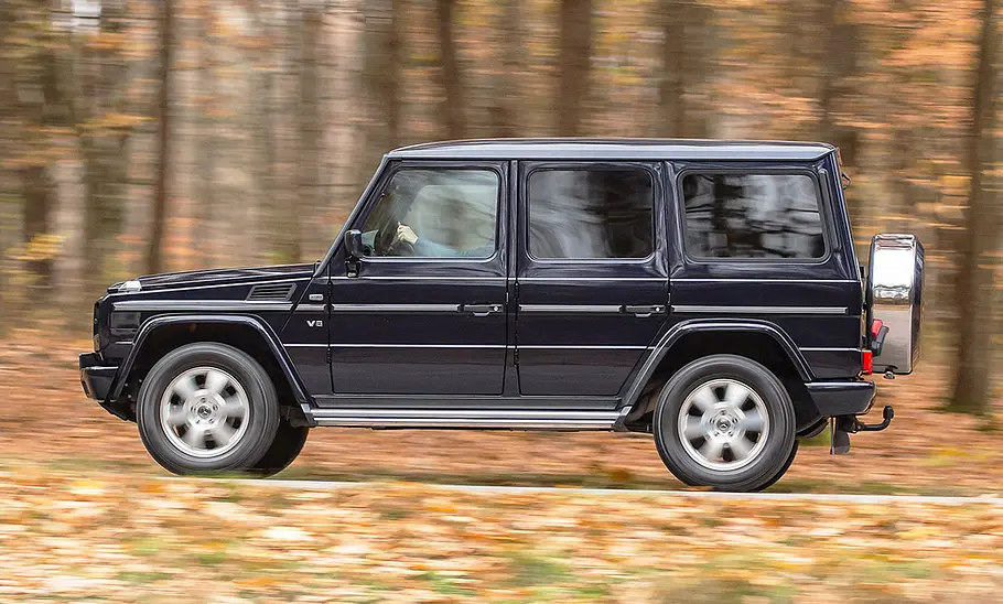 Mercedes G-Klasse (W463) Die Mercedes G-Klasse (W463) fährt an einem Wald entlang, von links fotografiert.