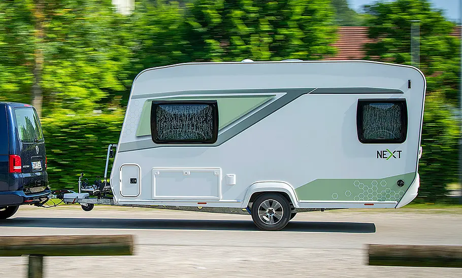 Neuer Next 380 (2025) Die Außenaufnahme zeigt den Next 380 (2025) von einem VW T6 gezogen fahrend von links.