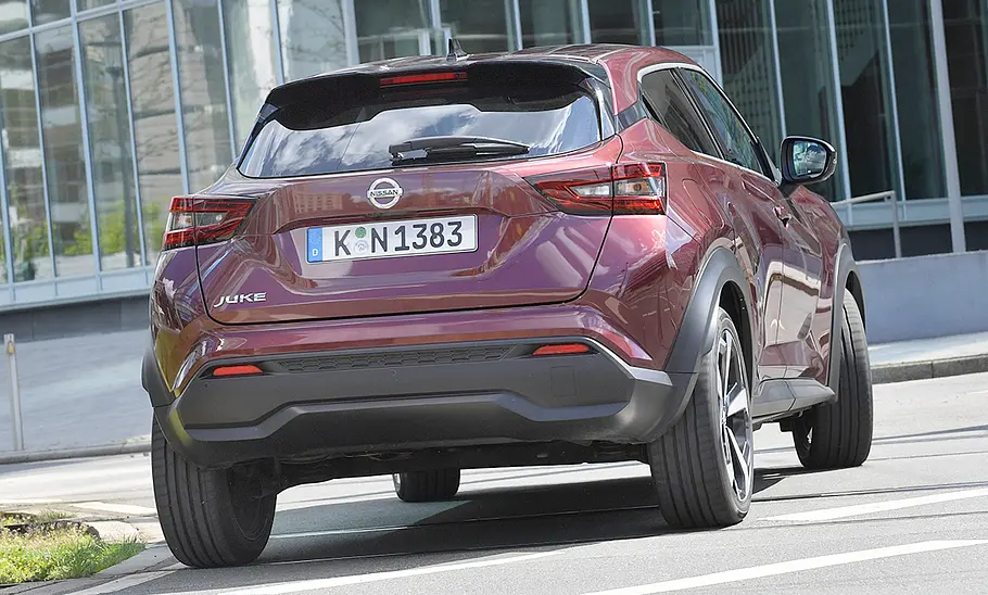 Der Nissan Juke (2019) fährt durch eine urbane Umgebung, von hinten fotografiert.