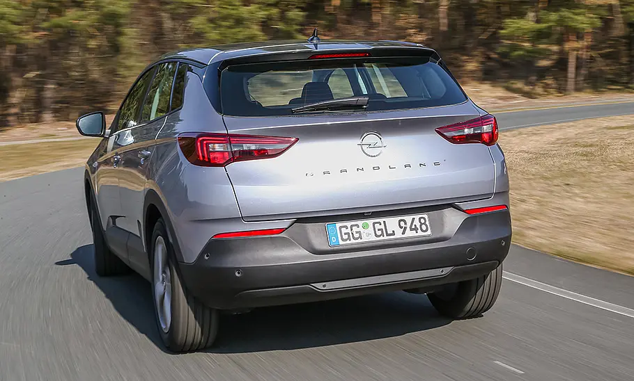 Opel Grandland (2021) Der Opel Grandland (2021) fährt eine Rechtskurve, von hinten fotografiert