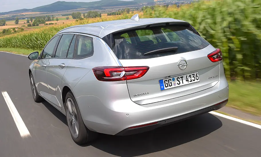 Der Opel Insignia Sports Tourer (2017) fährt eine Straße entlang, von hinten links fotografiert.