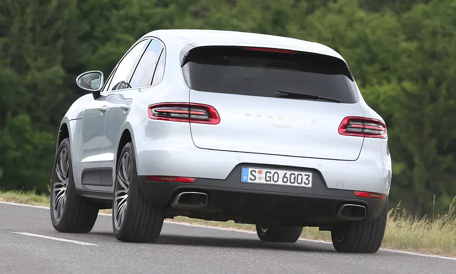 Porsche Macan (2018) fährt durch eine Linkskurve, von hinten fotografiert.