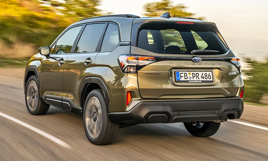 Subaru Forester (2025) Subaru Forester (2025) fährt auf einer Landstraße, Ansicht von hinten links.