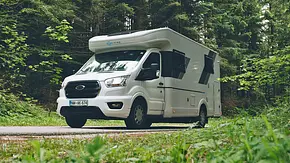 Der Sunliving S 72 DL auf einem asphaltierten Waldweg zwischen Bäumen stehend von schräg vorne links. - Foto: Sunliving