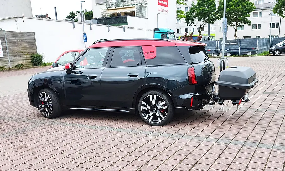 Heckbox Thule Santu Heckbox Thule Santu am Testwagen auf dem Parkplatz eines Supermarkts, im Profil.