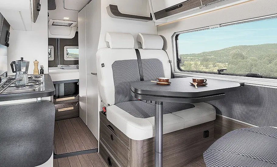 Van Tourer 540 D Wohnraum des Van Tourer 540 D (2025). Ansicht der Sitzgruppe und des Gangs nach hinten.