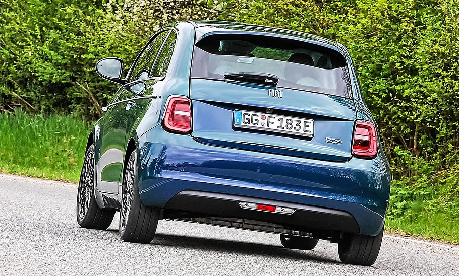 Blick von schräg hinten auf den fahrenden Fiat 500 Elektro.