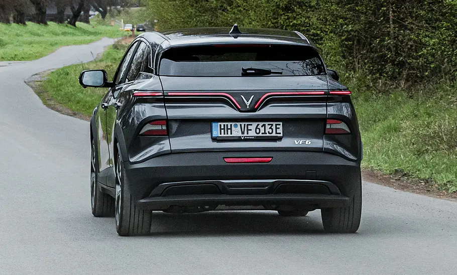 Vinfast VF 6 (2025) Der Vinfast VF 6 fährt über eine Landstraße, fotografiert von schräg hinten.