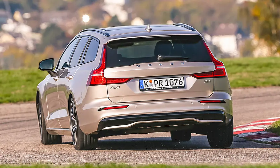 Der Volvo V60 (2018) fährt auf einer Rundstrecke eine Rechtskurve, von hinten fotografiert.