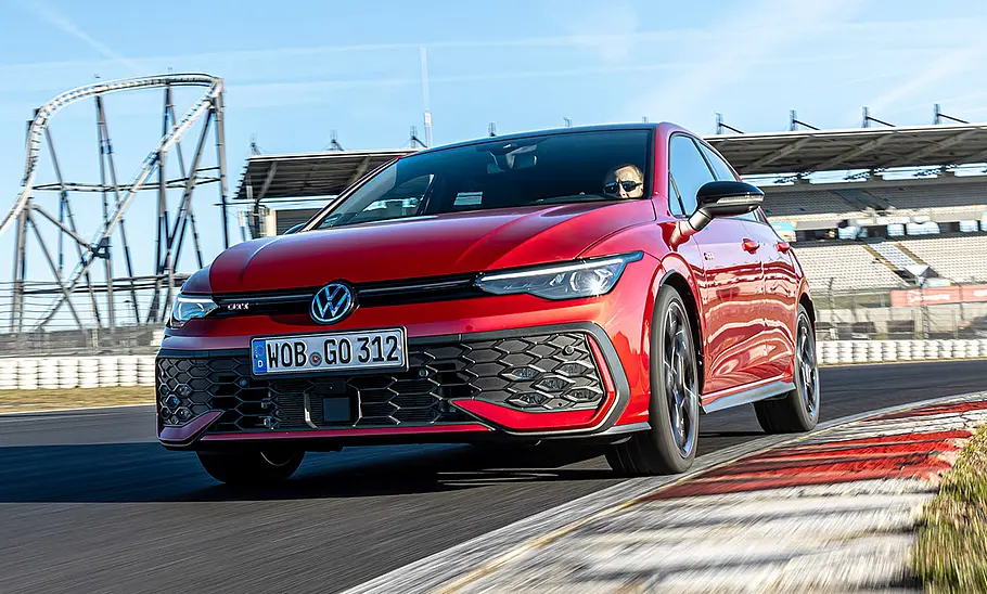 Der VW Golf GTI fährt auf der Grand-Prix-Strecke des Nürburgring durch eine Linkskurve, von vorne links fotografiert.