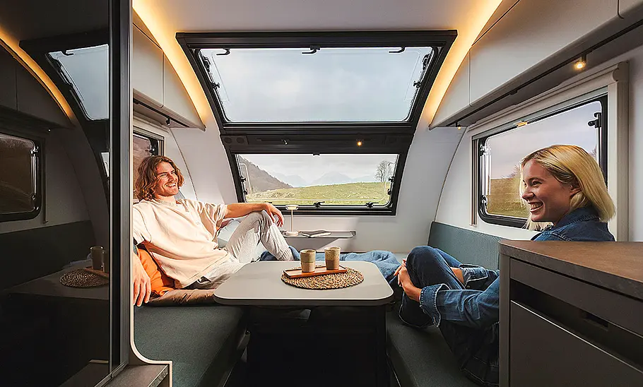 Die Sitzgruppe des Adria Action Sports 391 LH (2025). Zwei Personen sitzen auf den Bänken.