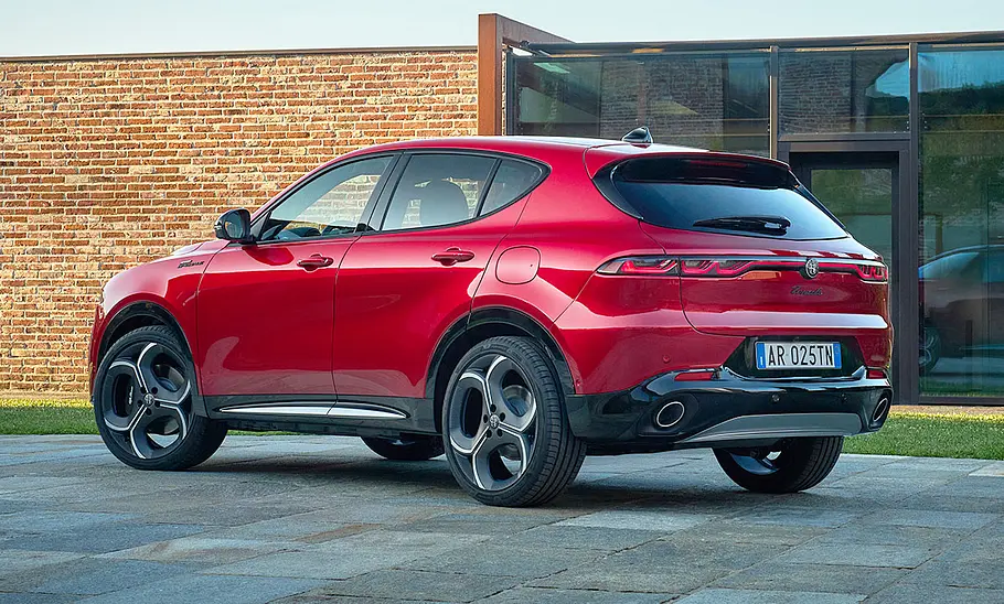 Alfa Romeo Tonale Facelift (2025) Das Alfa Romeo Tonale Facelift (2025) steht vor einem modernen Haus, von hinten links fotografiert.
