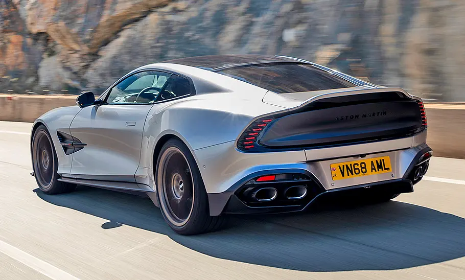 Fahrender Aston Martin Vanquish (2024) von schräg hinten links.