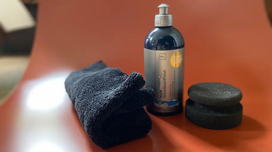 Draufsicht auf ShineSpeedPolish von Koch-Chemie, mit Schwamm und Tuch.