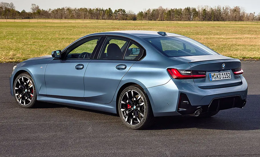 Das BMW 3er Facelift (2024) steht auf Asphalt, von hinten links fotografiert.