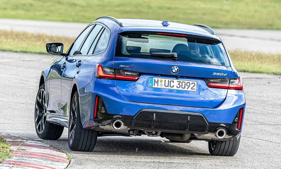 BMW 3er Touring Der BMW 3er Touring fährt durch eine Linkskurve, von hinten fotografiert.