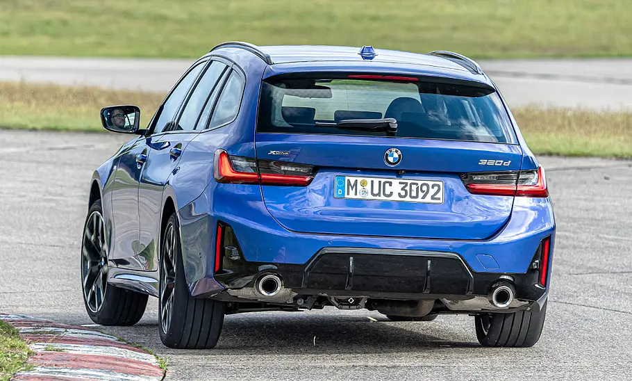 BMW 3er Touring Der BMW 3er Touring fährt durch eine Linkskurve. Von hinten fotografiert.