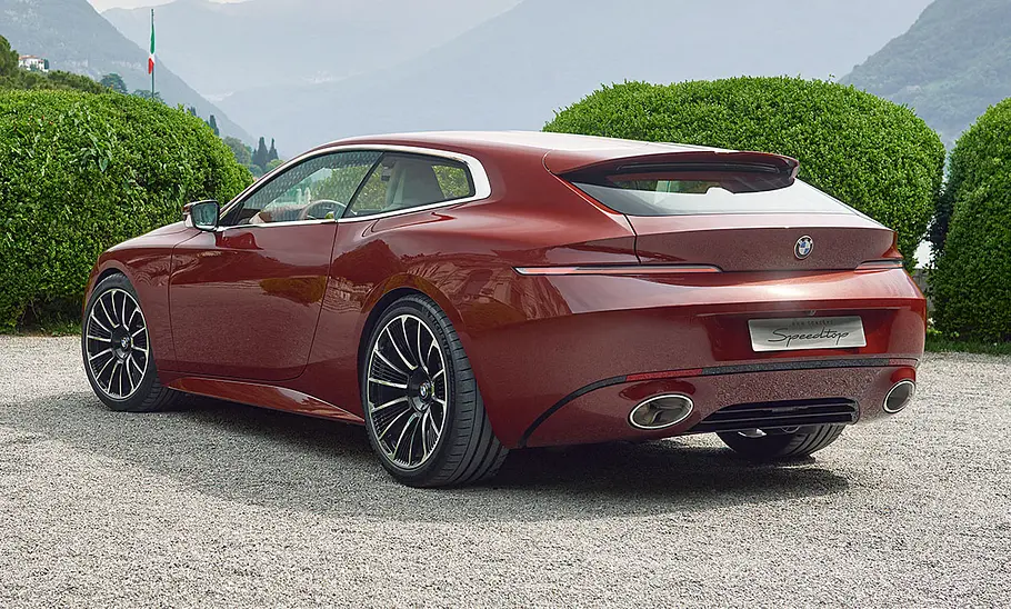 Das BMW Concept Speedtop (2025) steht in einem Park, von hinten links fotografiert.