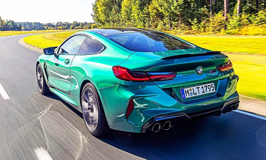 Der BMW M8 Competition fahrend von schräg hinten fotografiert.