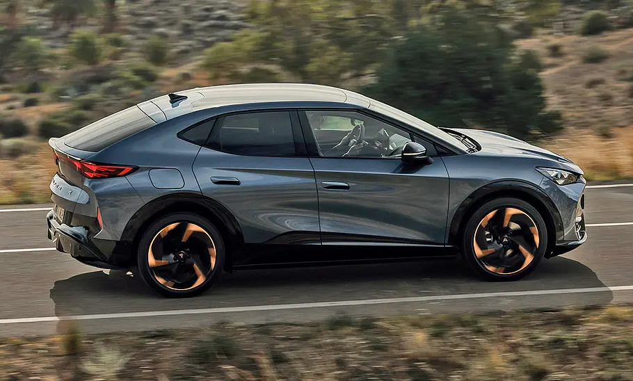 Der Cupra Tavascan (2024) fahrend von der Seite fotografiert.