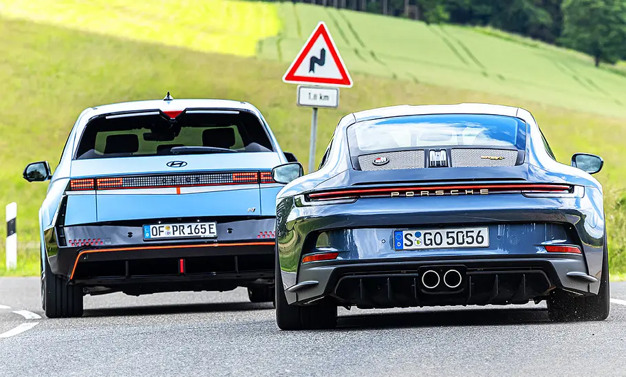 Porsche 911 S/T & Hyundai Ioniq 5 N Porsche 911 S/T schräg versetzt hinter Hyundai Ioniq 5 N fahrend, Heckansicht auf asphaltierter Straße fahrend