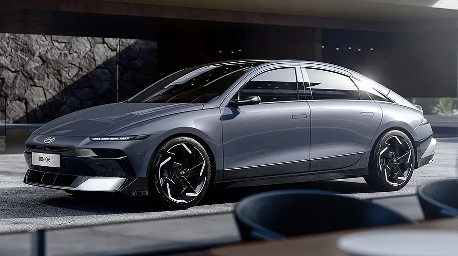 Hyundai Ioniq 6 Facelift Das Hyundai Ioniq 6 Facelift steht in einem Raum mit Steinwänden, von vorne links fotografiert.