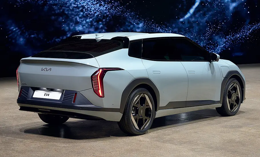 Der Kia EV4 (2025) in Studioumgebung, von hinten rechts fotografiert.